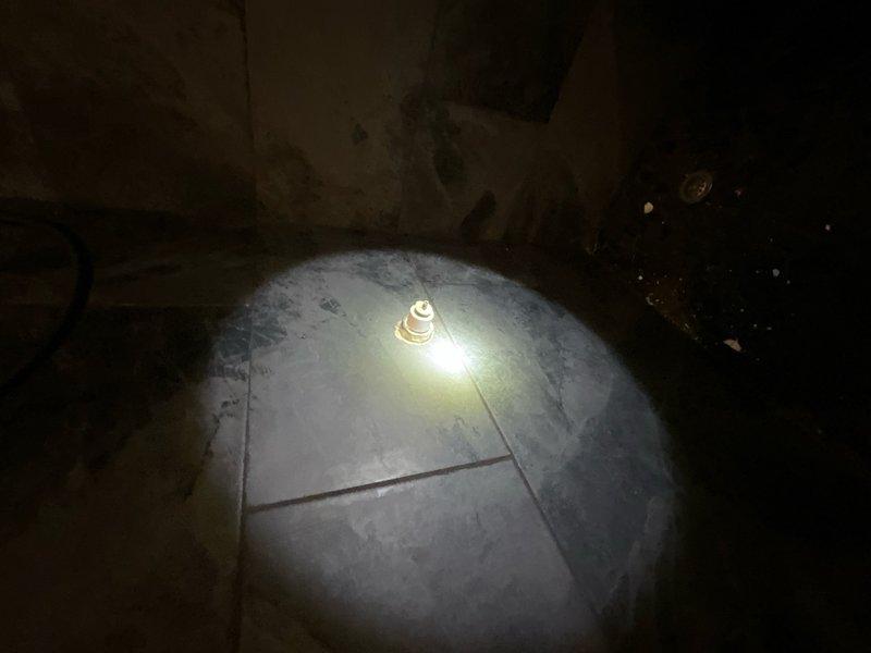 Responded to service call to inspect shower handle. Upon arrival, accessed crawl space beneath bathroom to examine plumbing connections and mounting hardware from below. Documented existing conditions with photos showing concrete floor surface and underside access point where shower valve assembly is located. No immediate repairs performed during this diagnostic visit.
