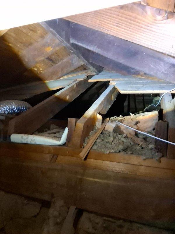 Conducted site assessment for ductwork estimate revision following structural modifications made by customer to basement wall area. Documented exposed ceiling infrastructure, displaced insulation, and damaged attic framing where wooden beams have collapsed, creating unsafe conditions with debris and compromised ductwork routing that will require new estimate calculations for proper HVAC system installation.