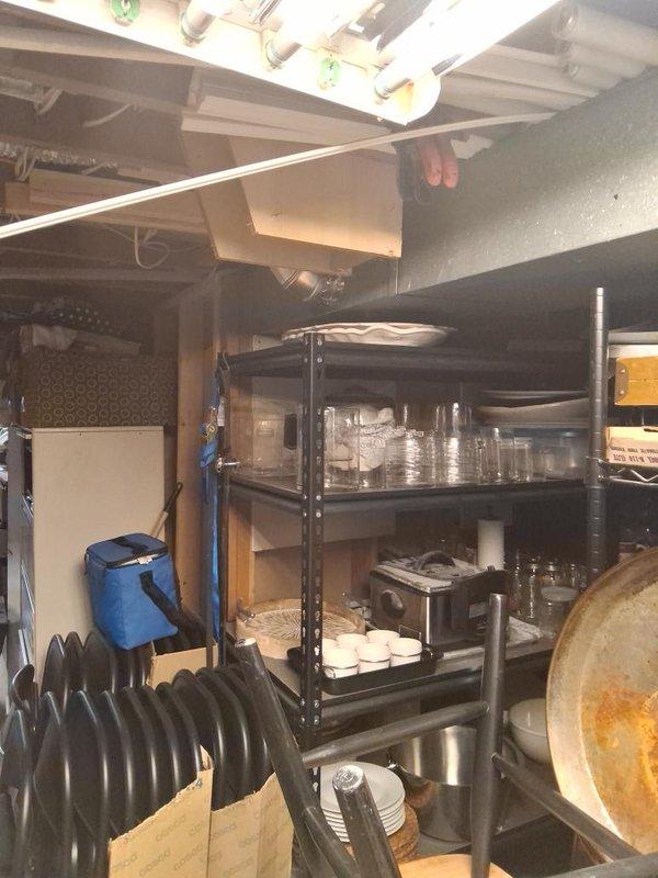 Conducted comprehensive ductwork assessment in basement area with exposed ceiling joists and existing HVAC infrastructure. Evaluated current flexible ductwork configuration, documented existing mechanical equipment including water heater and heating unit, and photographed space constraints around storage areas and shelving units to determine optimal routing for proposed ductwork installation.
