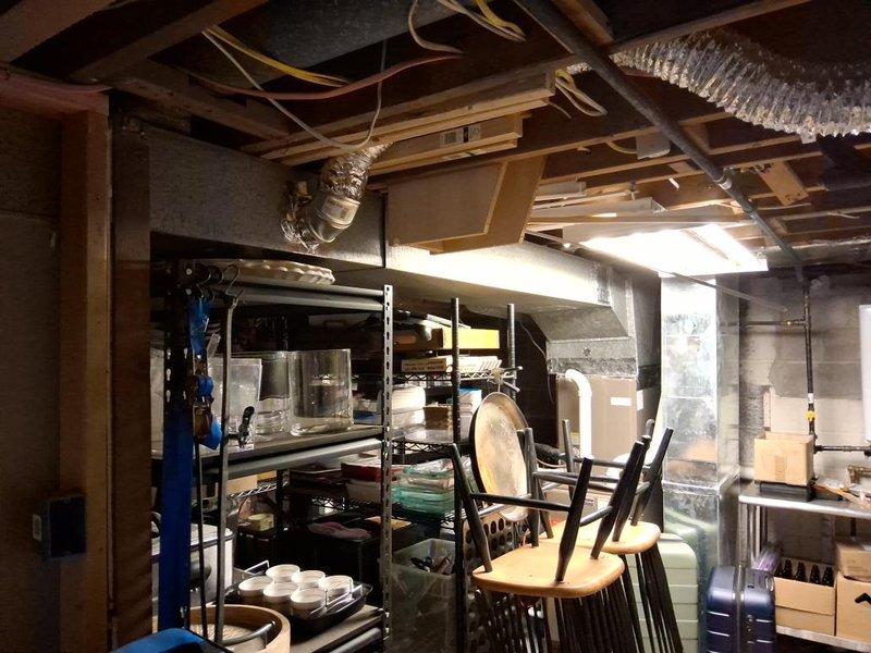 Conducted comprehensive ductwork assessment in basement area with exposed ceiling joists and existing HVAC infrastructure. Evaluated current flexible ductwork configuration, documented existing mechanical equipment including water heater and heating unit, and photographed space constraints around storage areas and shelving units to determine optimal routing for proposed ductwork installation.