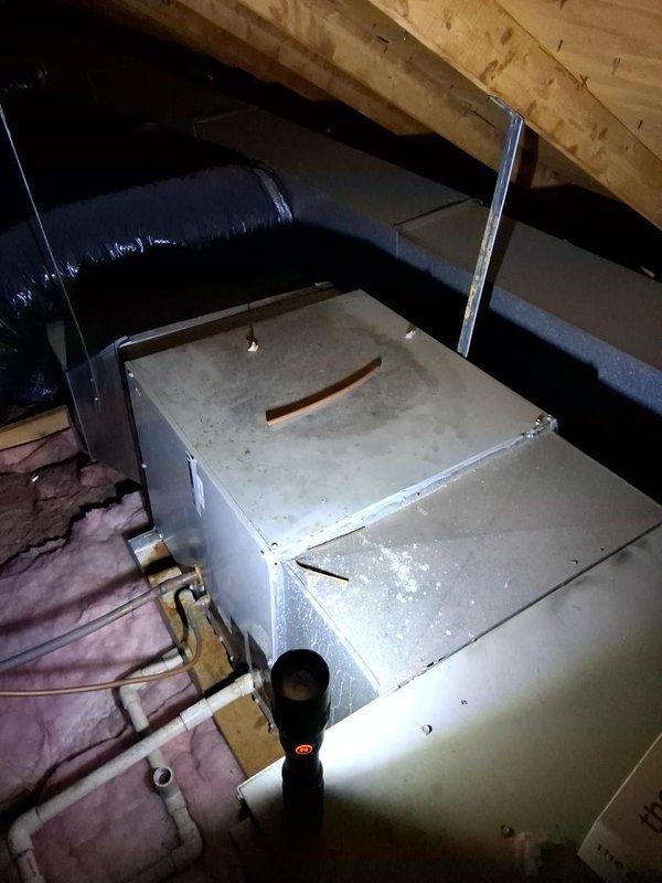 Completed estimate for residential air conditioning system. Inspected attic-mounted air handler with associated ductwork and refrigerant lines, confirming standard installation with fiberglass insulation present. Evaluated two outdoor condenser units positioned side by side with vegetation growth noted around equipment. Documented system configuration and current condition through photographic records for estimate preparation.