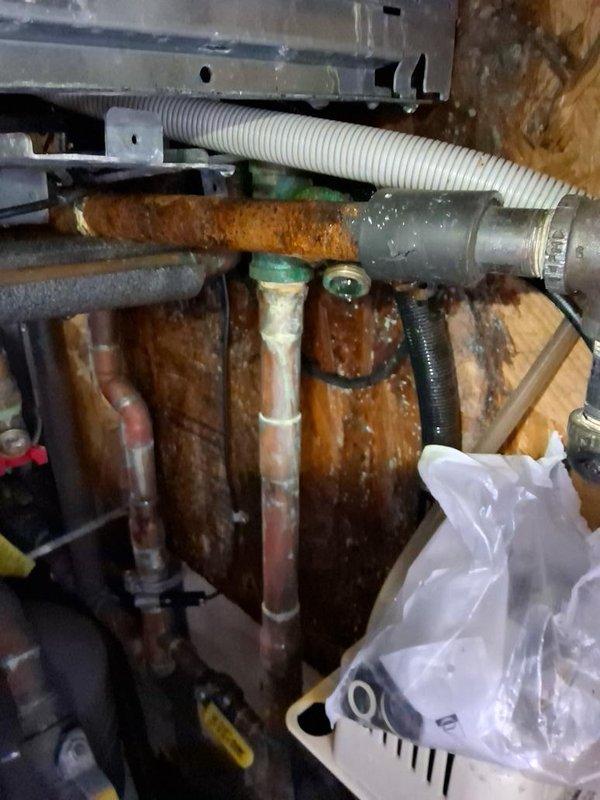Responded to service call for combi boiler system leaking unknown substance. Upon inspection, identified extensive corrosion and rust on primary condensate drain piping beneath unit, indicating long-term moisture exposure and deterioration of drainage system components. Assessed internal boiler components and verified condensate trap and drainage pathways for proper function. Documented conditions of corroded piping, copper supply lines, and associated plumbing connections for recommended repairs to prevent further water damage and ensure proper system operation.