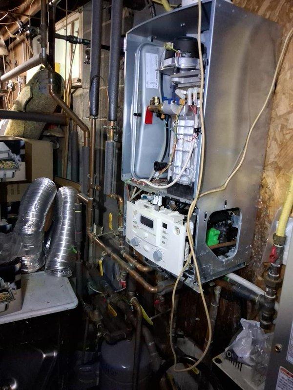 Responded to service call for combi boiler system leaking unknown substance. Upon inspection, identified extensive corrosion and rust on primary condensate drain piping beneath unit, indicating long-term moisture exposure and deterioration of drainage system components. Assessed internal boiler components and verified condensate trap and drainage pathways for proper function. Documented conditions of corroded piping, copper supply lines, and associated plumbing connections for recommended repairs to prevent further water damage and ensure proper system operation.
