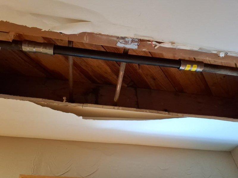 Responded to gas leak repair call with scheduled arrival window. Upon inspection, identified compromised gas piping system requiring immediate attention. Performed necessary access work through ceiling and wall areas to expose affected gas lines. Executed complete gas repipe installation, removing deteriorated sections and installing new black iron gas piping with proper fittings and connections. Installed new shut-off valve for system isolation and safety compliance. Routed new gas line through structural joists following code requirements for proper support and clearance. Pressure tested entire gas system to verify integrity and confirm zero leakage at all connections and joints. Restored gas service to affected appliances and verified proper operation. Tagged new installation for inspection compliance. Work completed successfully with all safety protocols observed.