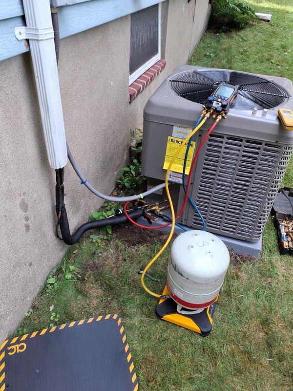 Completed installation of new residential air conditioning condenser unit on exterior concrete pad. Installed refrigerant lines with proper insulation and secured line set to building exterior using appropriate mounting hardware and protective conduit. Performed system evacuation using vacuum pump to remove moisture and contaminants from refrigerant lines. Charged system with refrigerant to manufacturer specifications using manifold gauge set and recovery equipment. Verified electrical connections at disconnect box and tested unit operation. Confirmed proper airflow through condenser fan and checked all service valves for secure connections and proper sealing.