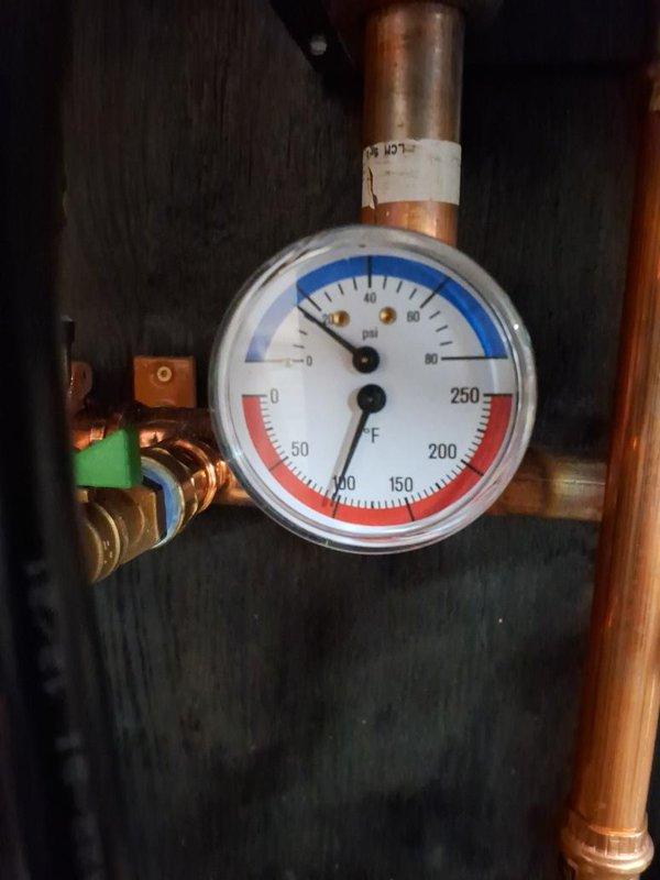 Responded to no hot water call during scheduled 8am-10am arrival window for boiler system evaluation. Upon inspection, diagnosed issues with the heating system's pressure regulation and circulation components. Examined the pressure and temperature gauge assembly, which monitors both PSI (0-80 range) and temperature (0-250°F range) to ensure proper system operation. 

Inspected the main valve manifold configuration consisting of multiple copper pipe connections with ball valves for system isolation and flow control. Evaluated the central pressure regulator component and associated brass fittings that control water pressure throughout the heating distribution system. Checked all valve positions and verified proper operation of isolation valves equipped with yellow handles for maintenance access points.

Assessed the circulation pump and control unit for proper electrical operation and mechanical function. Examined flexible connector hoses and verified integrity of all copper pipe joints 