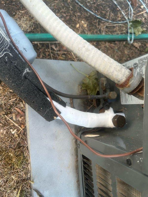 Responded to no cooling call and found ducted air conditioning system with frozen evaporator coil upon arrival. Inspected attic-mounted air handler and confirmed ice buildup on coil and refrigerant lines. Examined outdoor condensing unit and associated refrigerant piping, noting oxidation on copper lines and weathered insulation. Shut down system to allow complete defrost cycle of evaporator coil. Checked airflow at air handler and found restricted airflow due to insufficient return air or dirty filter causing coil temperature to drop below freezing point. Verified refrigerant line insulation integrity on both suction and liquid lines. Allowed adequate time for ice to melt completely before further diagnostics. System requires follow-up service to address underlying cause of freeze condition, which may include checking refrigerant charge levels, verifying proper airflow across evaporator coil, inspecting blower motor operation, and replacing air filter if restricted.