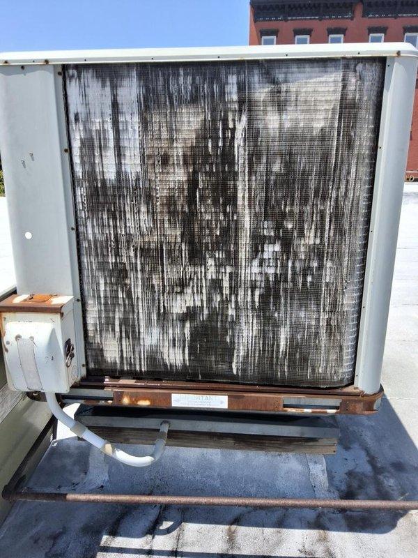 # No AC Service Completed

Responded to a commercial refrigeration complaint regarding insufficient cooling. Upon arrival, conducted a thorough inspection of the rooftop HVAC unit and discovered severely deteriorated condenser coil with extensive biological growth, dirt accumulation, and dark vertical streaking patterns covering the entire coil surface. The heavy contamination was significantly restricting airflow and reducing heat transfer efficiency, directly causing the inadequate cooling performance.

Performed complete condenser coil cleaning using professional-grade coil cleaner and pressure washing equipment to remove years of accumulated debris, algae, and environmental contaminants. Restored coil fins to proper condition and verified unrestricted airflow through the unit. Inspected drain pan and found rust-colored staining; cleared drain ports to ensure proper condensate drainage. Checked all electrical connections, refrigerant pressures, and system operation following cleanin