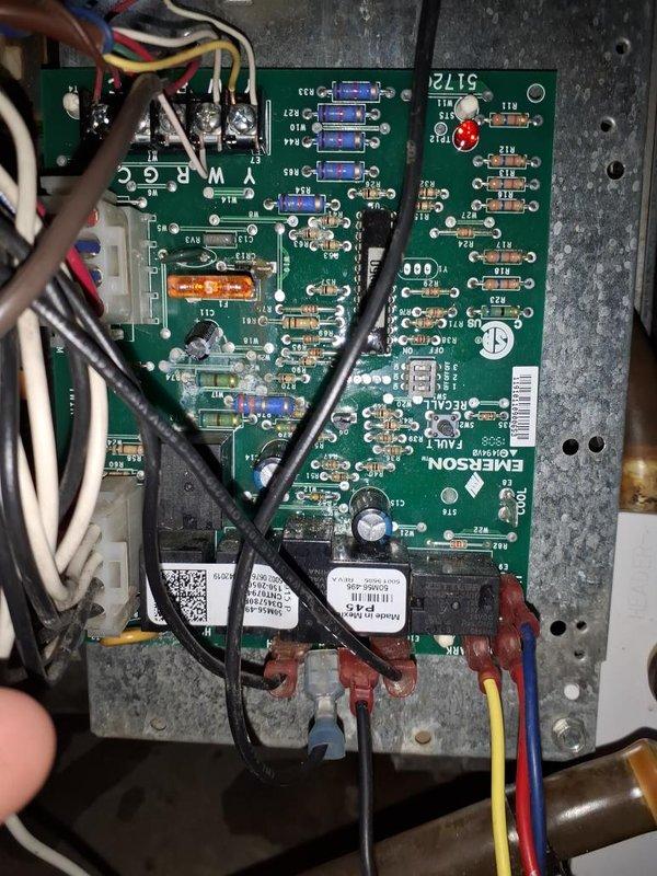 Responded to no heat call for Trane XR90 furnace serving main residence. Homeowner reported control board not illuminating despite verifying power supply, attempting reset, and replacing fuse. Upon inspection, confirmed Emerson control board had no power indication or LED status lights. Outdoor condensing unit was operational, indicating issue isolated to indoor air handler. Documented existing installation including ductwork configuration, Aprilaire humidifier integration, and control board wiring connections. Photographed control board showing multiple wire terminations, wire nuts, and component layout for diagnostic reference. Recommended control board replacement to restore heating operation.