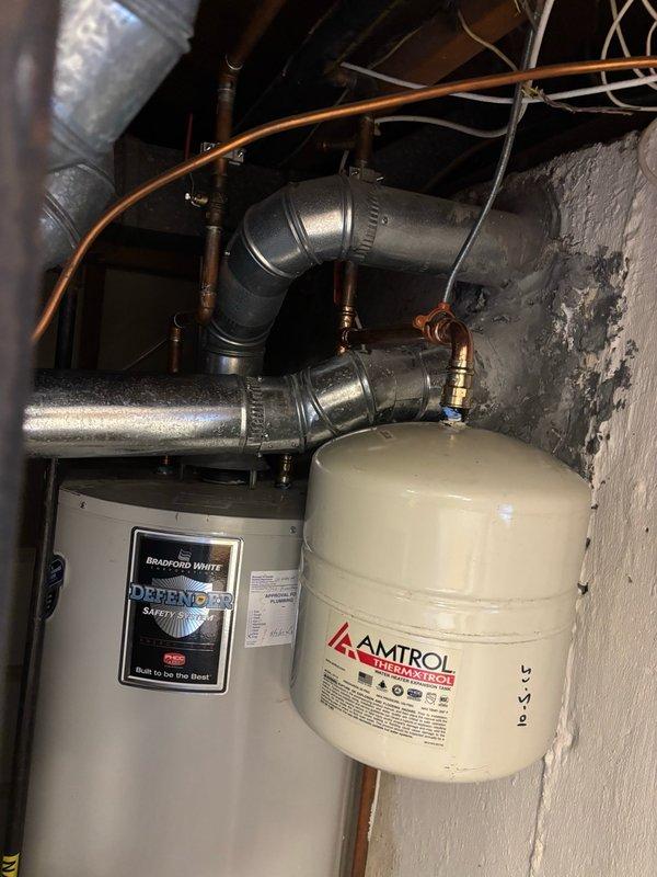 Responded to water heater leak complaint and performed comprehensive system inspection. Upon arrival, identified leak source and assessed related components including Bradford White Defender water heater unit, Amtrol expansion tank, and associated copper piping connections. Inspected system pressure using mounted Watts pressure gauge, which indicated elevated reading at approximately 120 PSI. Documented equipment conditions and plumbing configuration through photographic evidence. Evaluated expansion tank functionality and connection integrity to determine relationship to reported leak condition.
