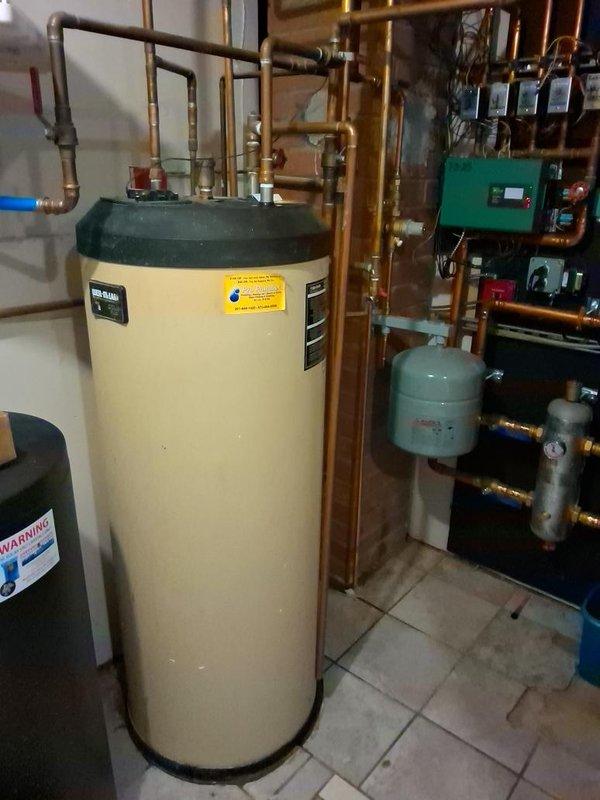 Responded to no hot water call for NTI TRX199C combi boiler that experienced repeated motherboard failures after recent replacement by another contractor. Upon inspection of the hydronic system, documented the existing installation including the combi boiler, expansion tanks, zone pumps, and associated copper piping with brass fittings. Assessed the system for underlying electrical issues that may have caused the secondary motherboard failure. Photographed the complete mechanical room setup showing the water heater, green control boxes, circulation components, and piping configuration to support warranty claim documentation, as unit is covered under manufacturer warranty.