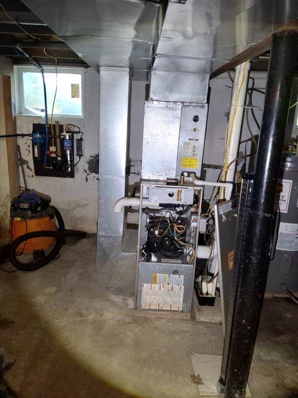 Conducted comprehensive assessment of existing HVAC system for furnace replacement estimate. Inspected Goodman central air conditioning unit (Model CACF036B2B) and furnace system in basement mechanical room. Documented current equipment specifications, including R22 refrigerant system manufactured in 2004, and evaluated ductwork configuration with main trunk line extending to upper levels. Photographed internal components with access panel removed to assess condition of electrical connections, wiring harness, and mechanical assemblies. Noted equipment age and overall system layout including proximity to water heater and existing ventilation infrastructure. Provided detailed documentation and specifications for complete furnace replacement proposal.