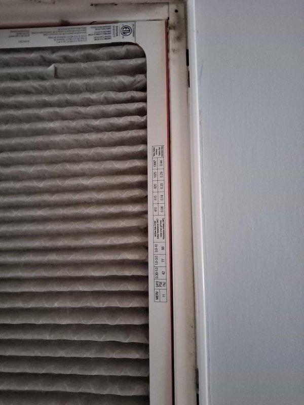 Completed seasonal maintenance on single-zone air conditioning system that had not been serviced in two years. Inspected return air grille and documented existing filter condition, noting dust accumulation on pleated media and rust staining on filter frame assembly, recommending filter replacement to maintain proper airflow and system efficiency.
