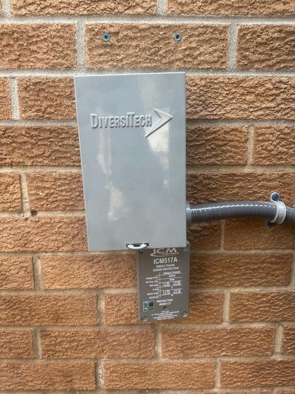 Replaced failed electrical disconnect on outdoor AC condenser unit. Installed new DiversiTech disconnect box with ICM517A specifications, mounted securely to exterior brick wall with proper conduit connections to ensure safe power supply to the system.