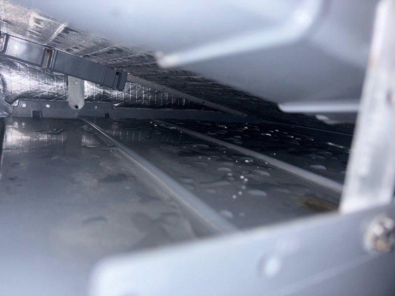 # No Cooling - Frozen Evaporator Coil

Responded to no cooling complaint and found evaporator coil completely frozen with heavy ice buildup and icicle formations. Coil exhibited significant dirt and debris accumulation restricting airflow. Identified frozen condensation throughout unit with water droplets present on multiple metal surfaces and components. System shut down to allow ice to thaw. Heavy soiling on coil fins indicated restricted airflow as primary cause of freezing condition. Recommended thorough coil cleaning and airflow verification once thaw complete to restore proper cooling operation and prevent recurrence.