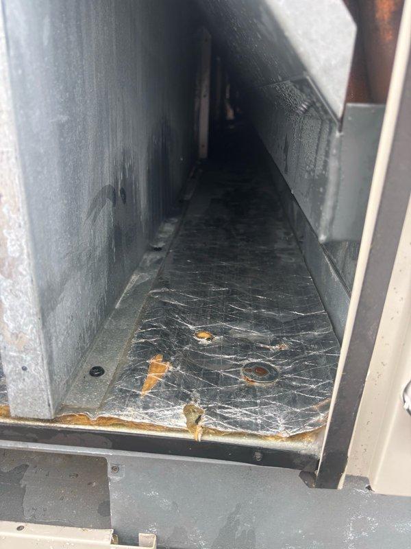 Conducted walkthrough inspection of third floor HVAC unit to investigate reported water leak and verify fan motor operation. Accessed unit interior and documented condition of internal components including blower assembly, refrigerant lines, and evaporator coil. Observed significant oxidation and discoloration on copper piping indicating age and environmental exposure. Confirmed presence of moisture accumulation within unit chamber with visible condensation on surfaces and metallic insulation material. Identified water pooling on chamber floor with debris present. Documented finned coil assembly condition and overall component arrangement for assessment. Obtained measurements and photographic documentation for curb adapter fabrication requirements to facilitate future equipment modifications.