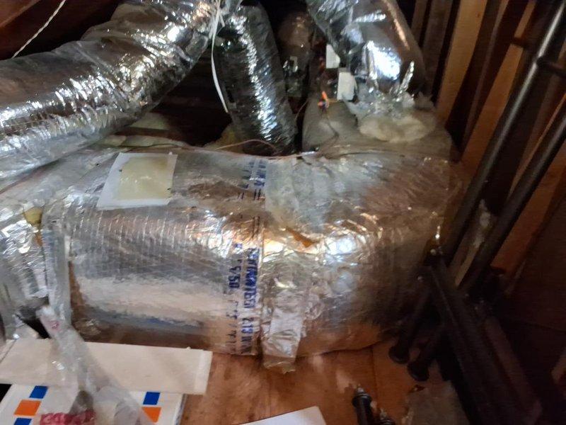 Conducted attic inspection and documentation of existing HVAC ductwork system to obtain measurements for complete duct replacement estimate. Photographed flexible aluminum ductwork showing significant deterioration including damaged insulation wrapping, visible staining, tears in vapor barrier, and evidence of previous repairs with tape and patching materials. Documented duct routing, configuration, and spatial constraints within confined attic space for accurate material takeoff and labor assessment.