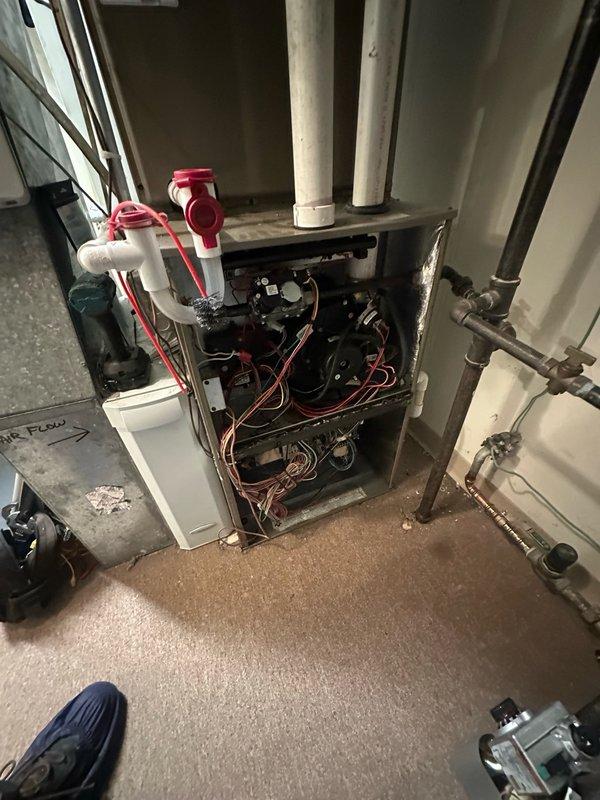 Responded to no cooling call and performed diagnostic inspection of HVAC system. Accessed furnace unit to examine blower motor assemblies, electrical connections, and control boards for potential issues affecting air conditioning operation. Documented internal components and wiring configuration, including blower motors, circuit boards, and condensate drainage system with PVC piping and ball valves.