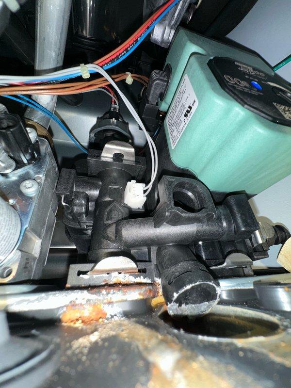 Responded to no hot water call involving indirect water heater system. Upon inspection, discovered significant corrosion and rust buildup on system components with evidence of active leaking. Circulator pump assembly showed moisture intrusion with brownish-orange fluid accumulation in base pan, indicating internal system contamination or corrosion byproduct. Assessed condition of pump, zone valves, and associated plumbing connections. Documented extensive rust damage on metal surfaces and mineral scale deposits suggesting prolonged water exposure. System requires component replacement and further evaluation to restore hot water functionality.