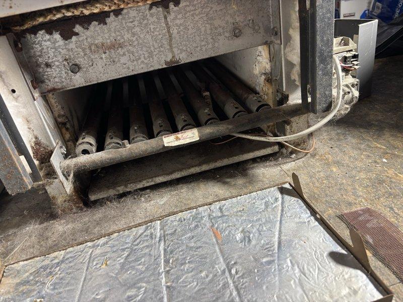 Completed scheduled gas furnace maintenance and tune-up. Inspected heat exchanger tubes which showed heavy dust and debris accumulation, along with visible corrosion on internal components and framework. Examined pressure tank and associated valve assembly in mechanical system. Equipment demonstrated signs of extended service period requiring thorough cleaning and continued monitoring for optimal performance.