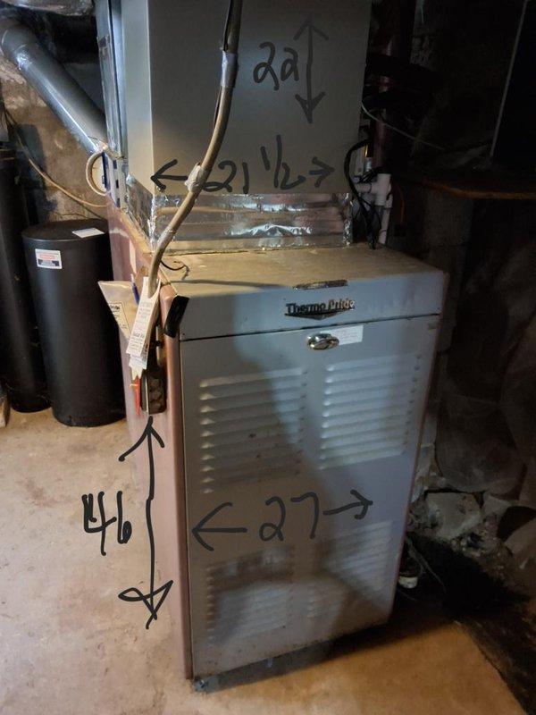 Performed an on-site evaluation for converting the existing oil-fired Thermo Pride furnace system to gas, documenting the furnace cabinet and supply plenum dimensions and inspecting the flue connection, adjacent water heater, and surrounding clearances. Assessed the air handler and ductwork, noting the plenum transitions, insulated flex duct runs, refrigerant line routing, and deteriorated duct tape and fiberglass insulation at several joints that will need sealing or replacement as part of the conversion.