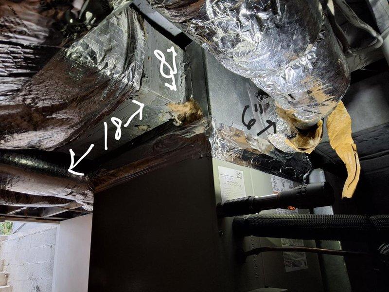 Performed an on-site evaluation for converting the existing oil-fired Thermo Pride furnace system to gas, documenting the furnace cabinet and supply plenum dimensions and inspecting the flue connection, adjacent water heater, and surrounding clearances. Assessed the air handler and ductwork, noting the plenum transitions, insulated flex duct runs, refrigerant line routing, and deteriorated duct tape and fiberglass insulation at several joints that will need sealing or replacement as part of the conversion.