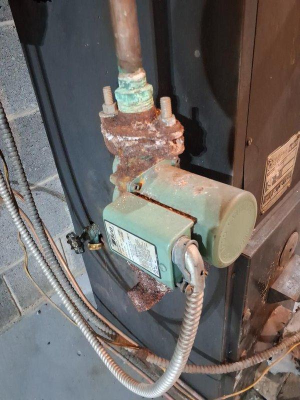 Performed annual maintenance on the oil-fired boiler, including a combustion efficiency test with a handheld analyzer while firing biodiesel-blend fuel; flue gas readings showed CO at 9 ppm with draft at 0.01 in. w.c. Inspected the system and noted significant rust and corrosion on the circulator pump flange, studs, and pump body, along with verdigris on the adjacent threaded fitting and corrosion on nearby piping. Recommend monitoring these areas for leaks and planning repair or replacement of the circulator pump flange assembly.