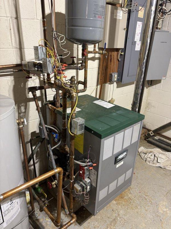 Responded to a no-heat call on a Peerless cast iron boiler, where the system was firing but failing to bring the home above 61°F despite a raised thermostat setpoint and good thermostat batteries. Inspection of the boiler and near-boiler piping revealed corrosion, discoloration, and rust staining at the copper piping and connections on top of the boiler, indicating a likely leak or water-side issue affecting heat output. The condition was documented with photos, and further repair of the affected piping and connections is recommended to restore reliable heat delivery.