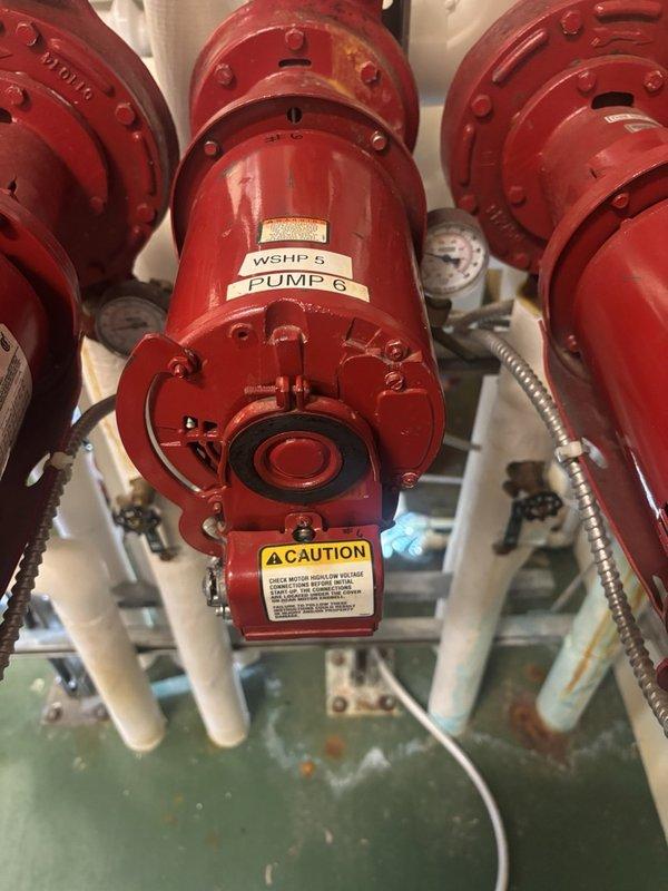 Responded to a no-heat complaint in the upstairs older main section of the building and inspected the mechanical room hydronic system, including the WSHP 5 and Pump 6 circulator motors, associated piping, valves, and pressure gauges. Evaluated pump #6 motor and housing, noting corrosion, flaking paint, and rusted fasteners on the flanges, along with mineral deposits and staining at the base of the piping that indicate possible leakage. Documented system condition with photos to support diagnosis and repair of the heating loop circulation issue.