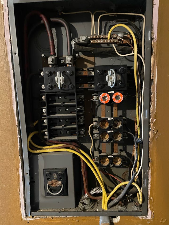 Electrician replacing old fuse box panel and doing a service upgrade