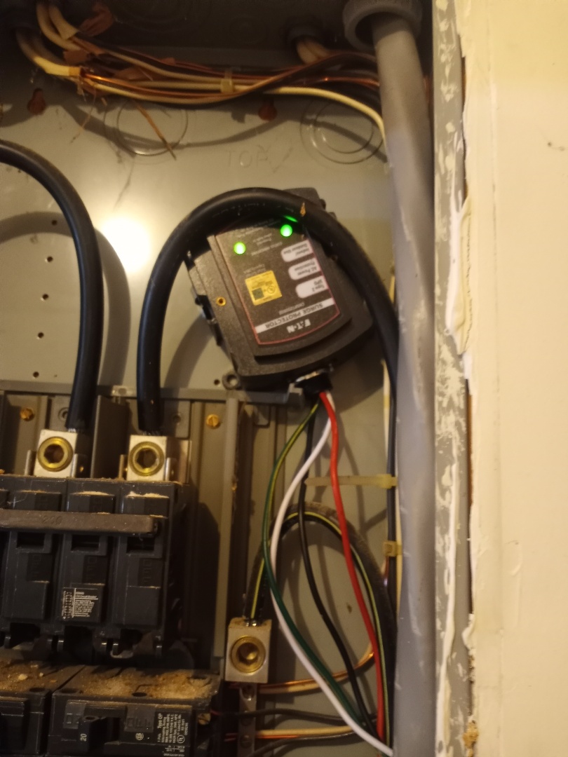 Electrician installing home surge protector