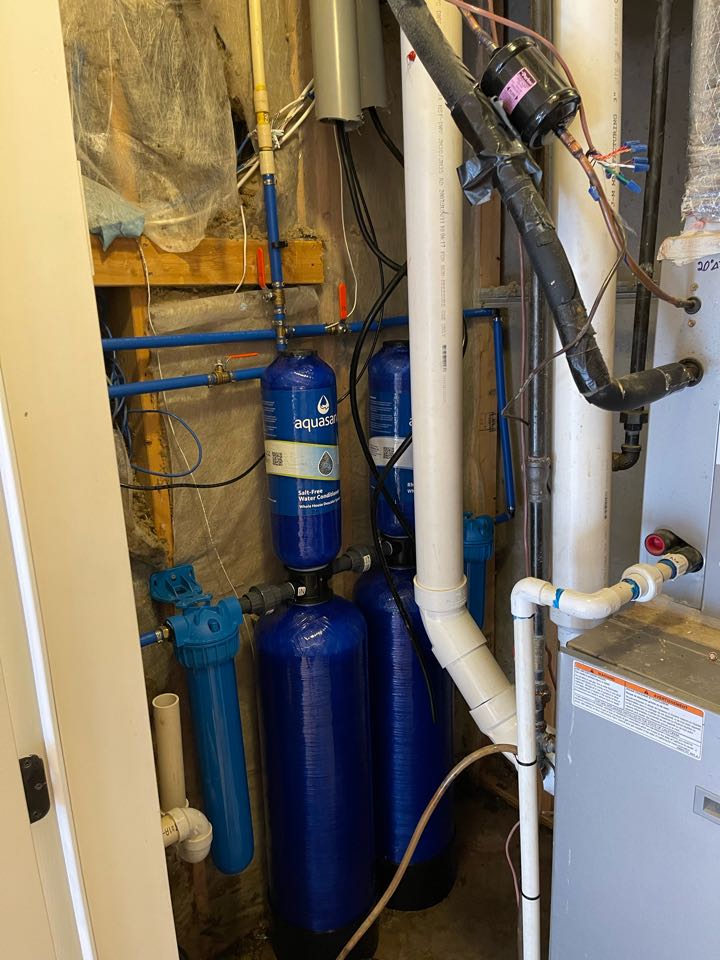 Plumber installing and replacing whole house water filtration system 