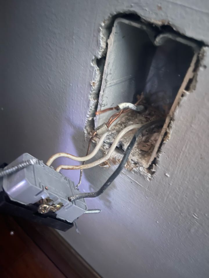 Electrician is repairing a broken wire in a outlet box that was causing no power to some of the house 