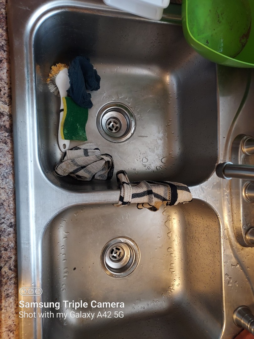 Plumber installing new kitchen strainers.