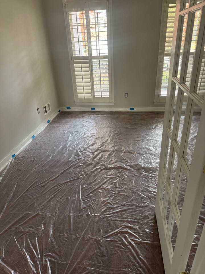 Electrician installing cans and fan in office area. 