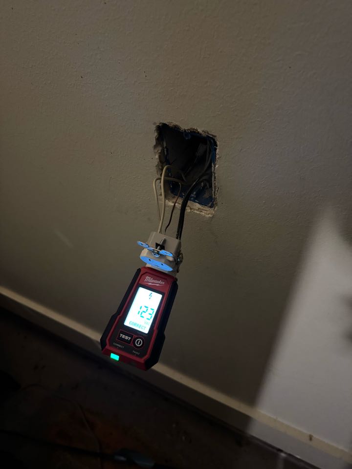 Electrician restoring power to fridge plug in garage