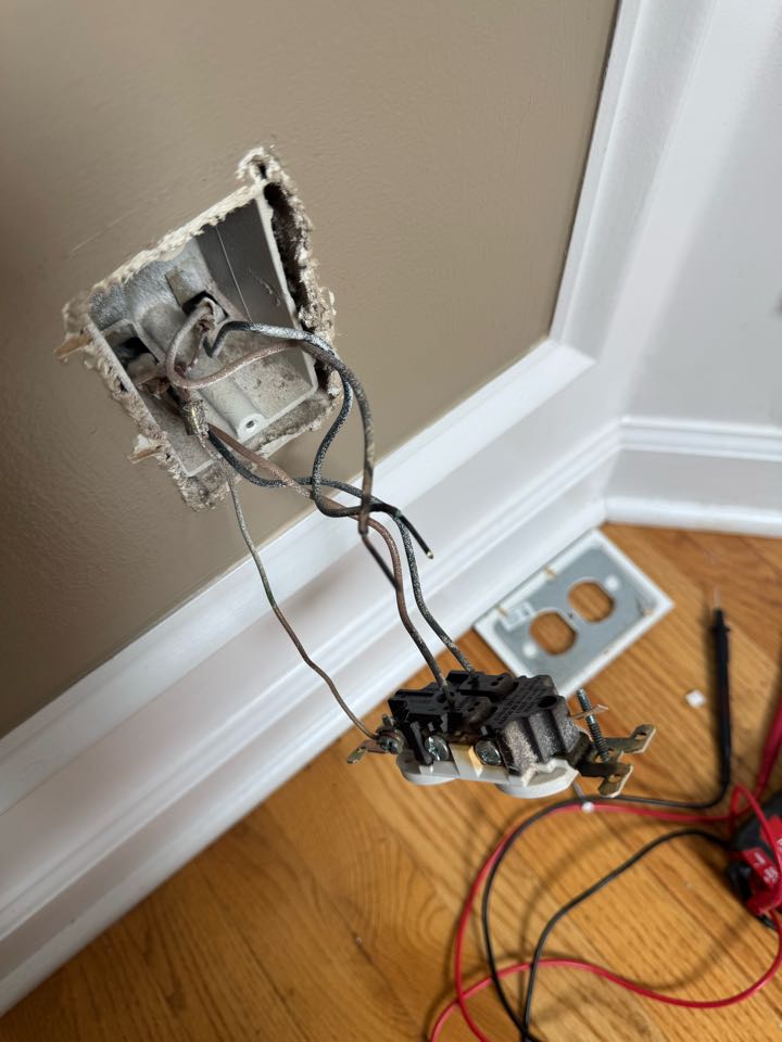 Electrician replacing burnt outlet. 