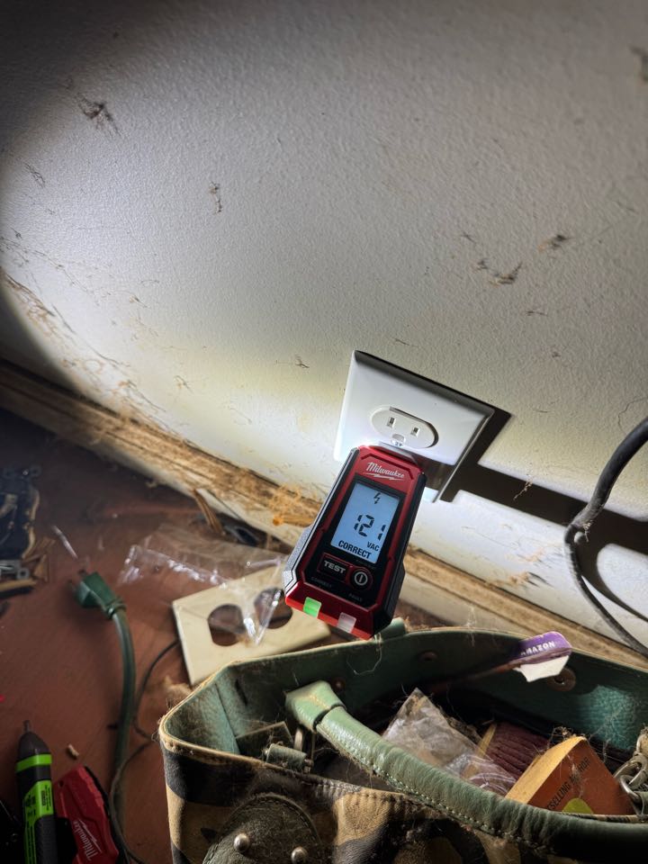 Electrician replacing outlet in bedroom