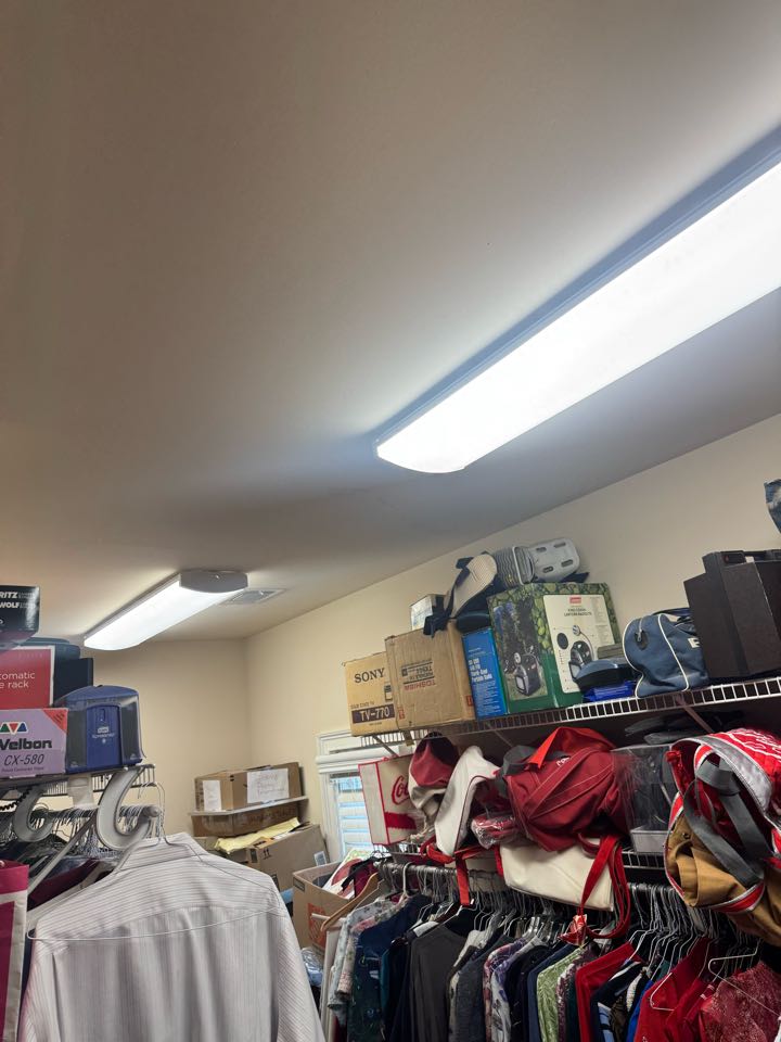 Electrician replacing fluorescent light fixtures in closet. 