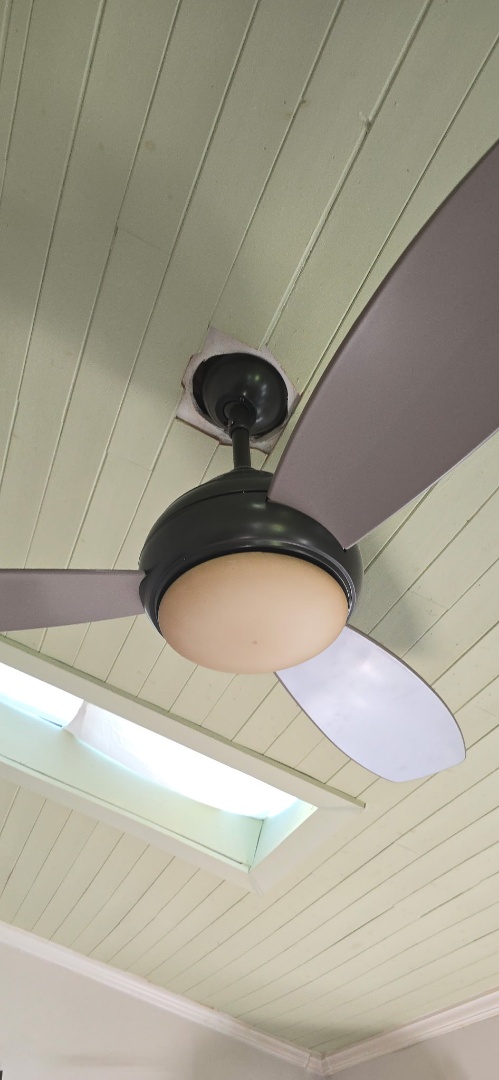 Electrician installing ceiling fan