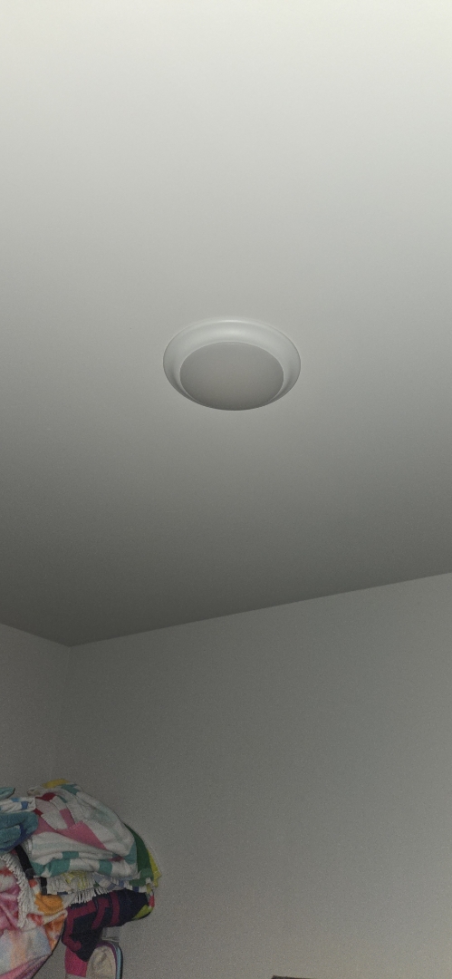 Electrician installing light fixture