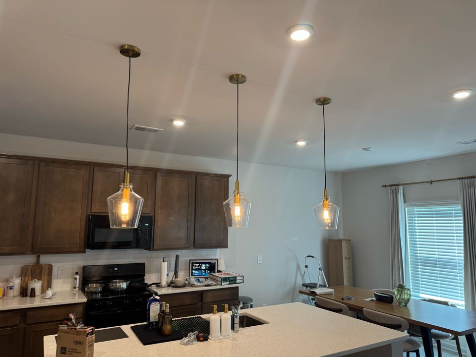 Electrician installing light fixtures. 
