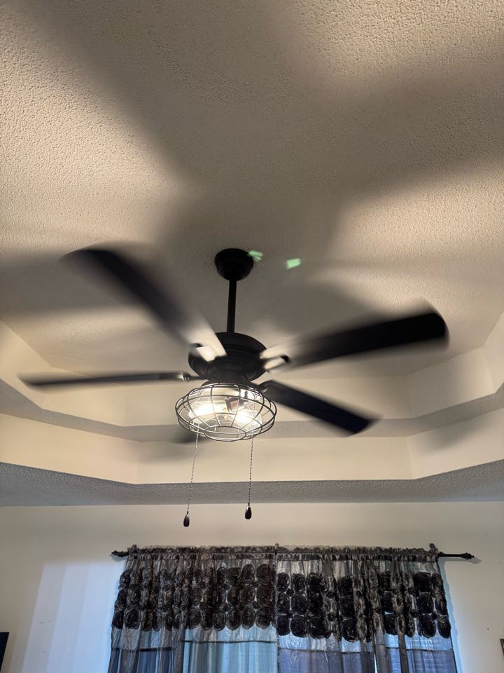 Electrician installing ceiling fan. 