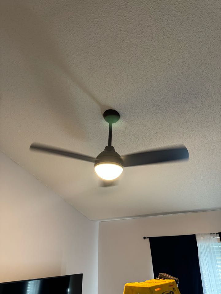 Electrician installing ceiling fan