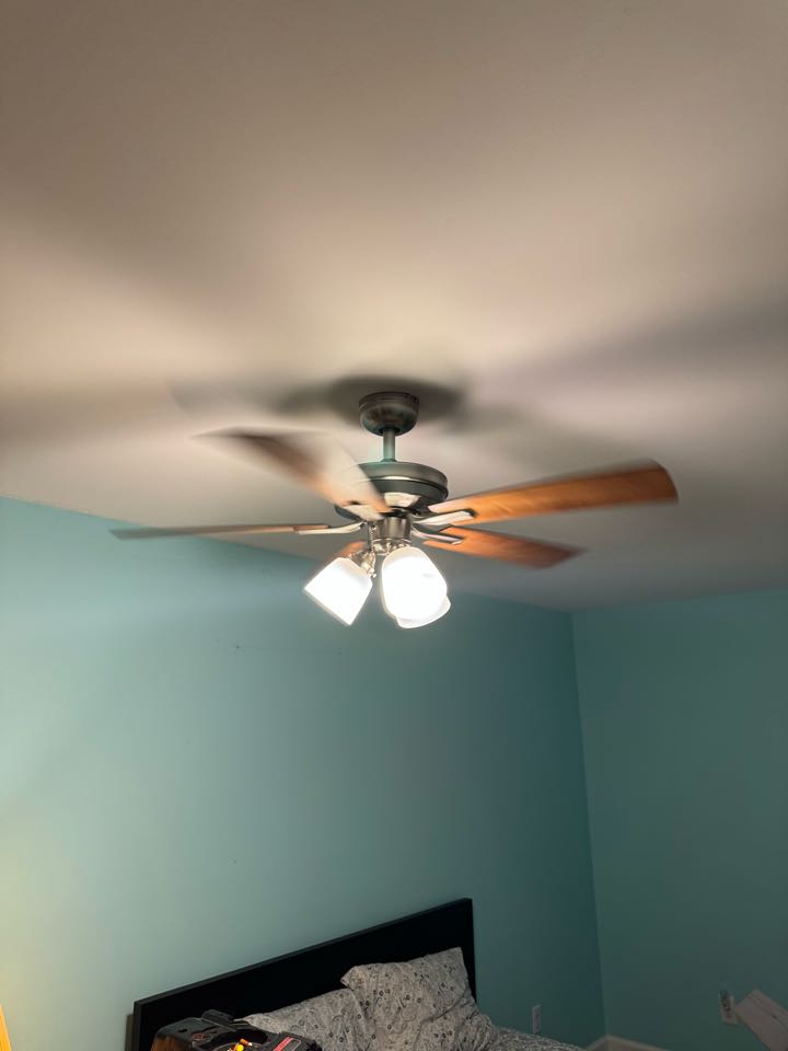 Electrician installing ceiling fan