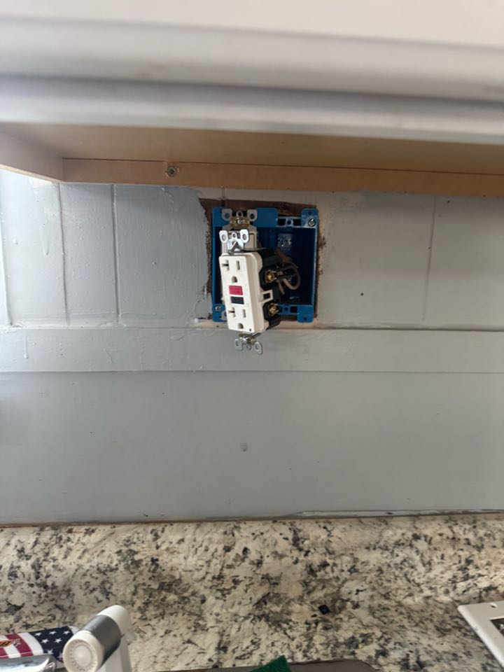 Electrician installing GFI in kitchen