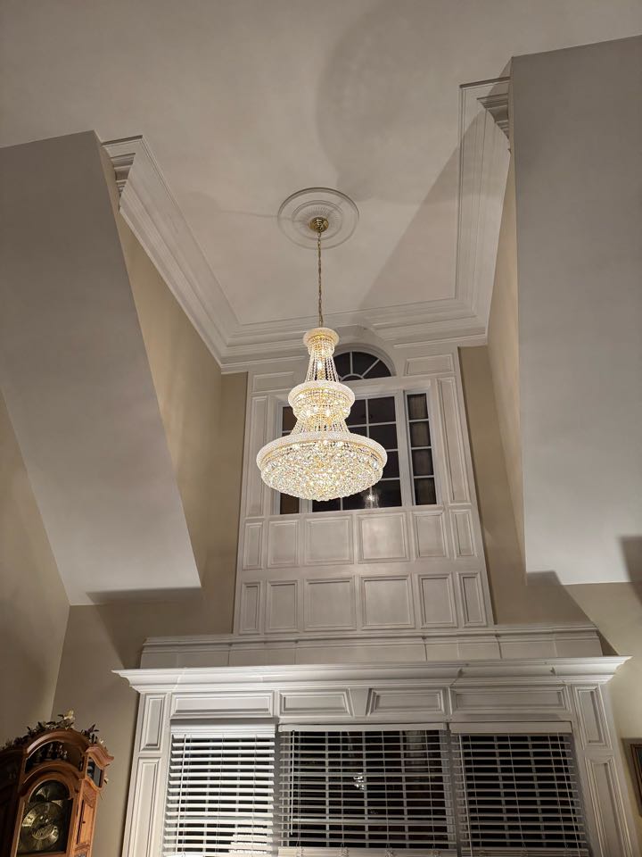 Electrician is installing a new large chandelier 