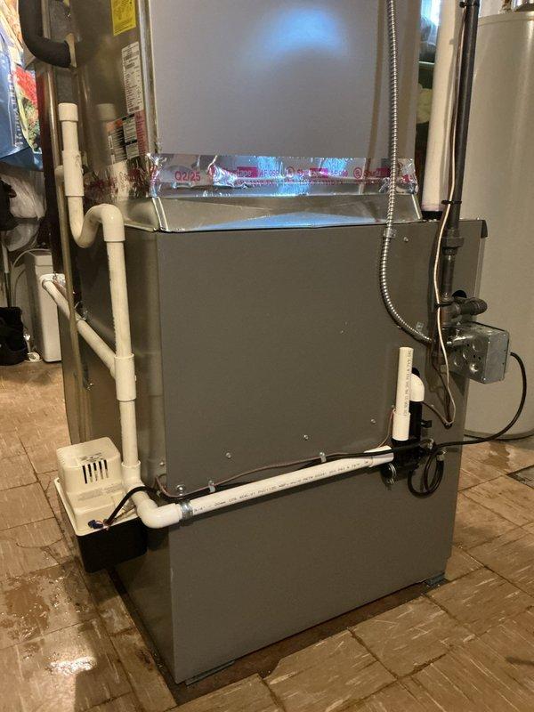 Responded to warranty call for water overflow issue on recently installed 90,000 BTU furnace system. Diagnosed and resolved condensate drainage problem from furnace cycling. System includes new furnace unit, raised coil, and Ecobee 3 lite thermostat with proper electrical and ventilation connections completed.