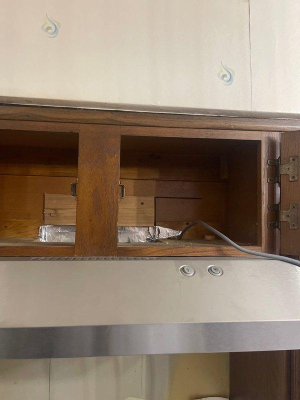Installed new electrical outlet above kitchen cabinet to power customer's range hood vent. Accessed interior cabinet wiring, ensuring proper connection while maintaining code compliance during the kitchen renovation process.