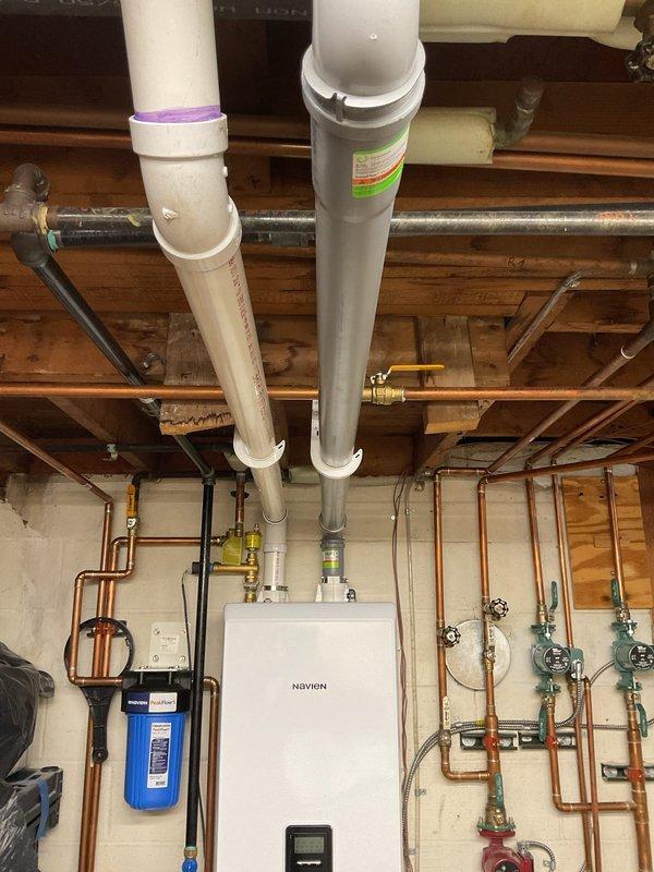 Completed warranty service on Navien combi unit installation. Installed polypropylene venting system with proper connections to existing plumbing network. System includes copper pipe connections, ball valves for maintenance access, and integration with home water filtration system.